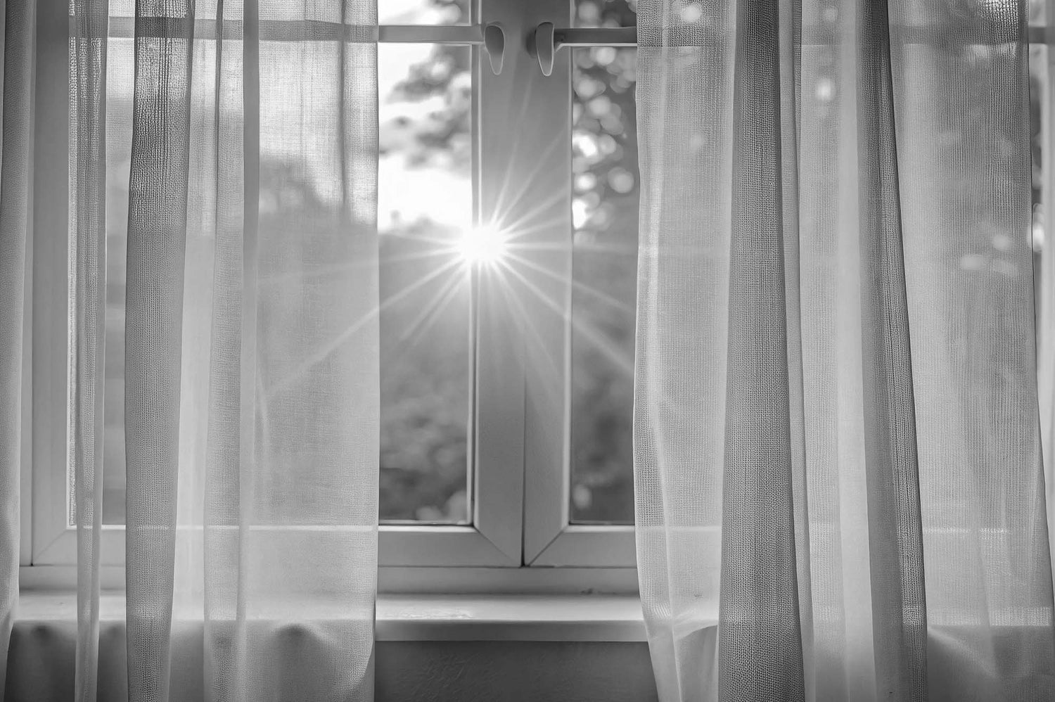 Sheer white curtains with a blurred outdoor background represnting th epeace and tranquility of lockdown