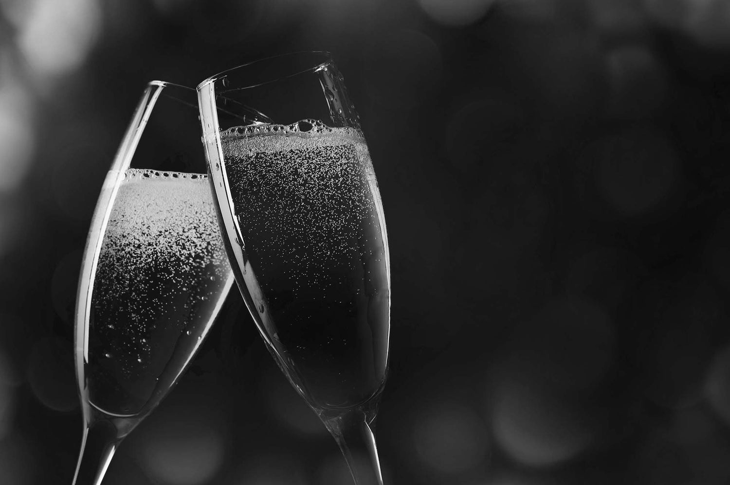Two champagne glasses with bubbles against a blurred background